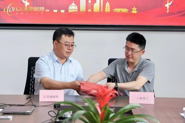康耐特技術總經理王傳寶（左）與上理工副教授項華中（右）就技術開發合同簽約現場照片。